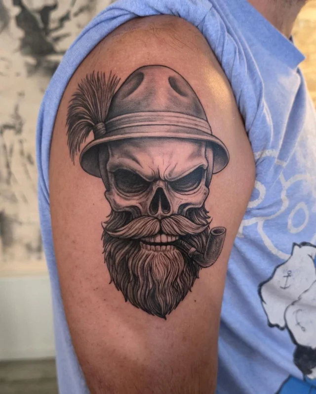 Calavera tatuada en black and grey en el brazo