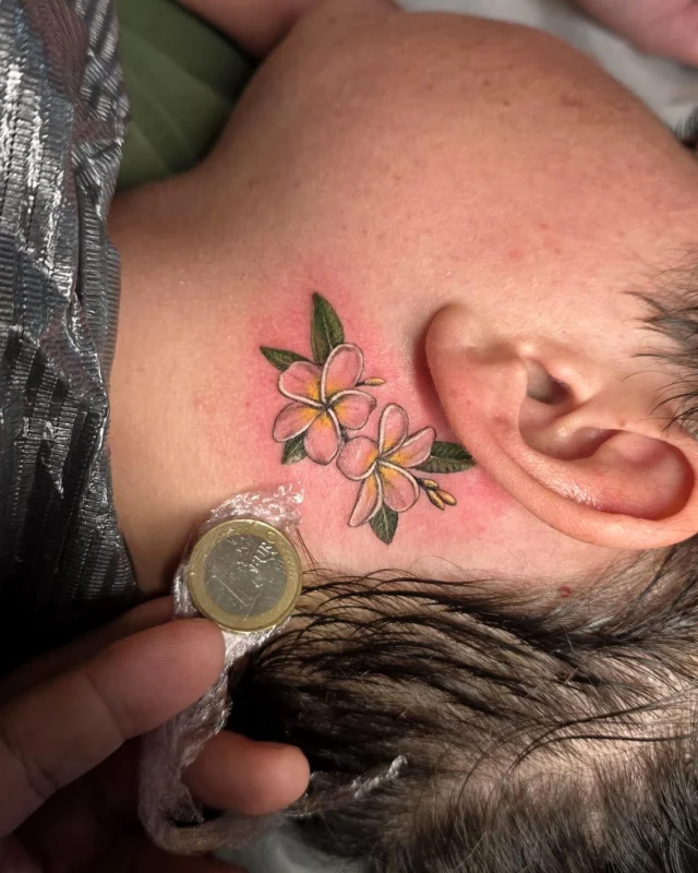 Flores tatuadas en color detrás de la oreja