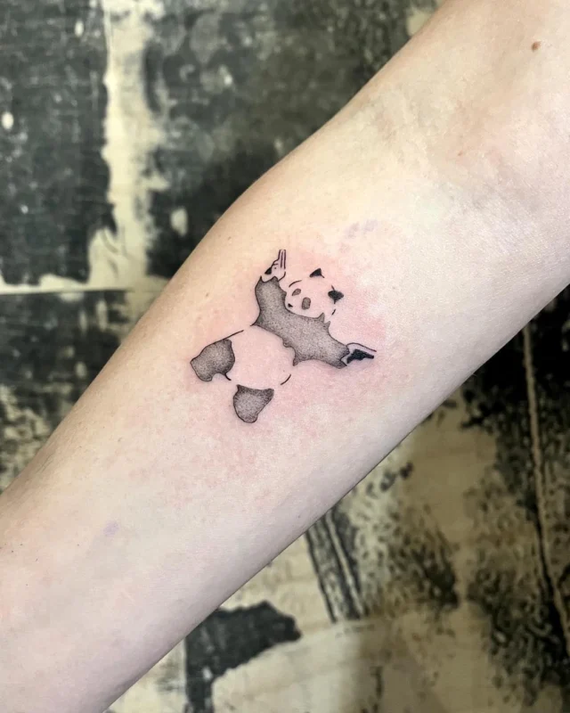Pequeño panda tatuado en el antebrazo